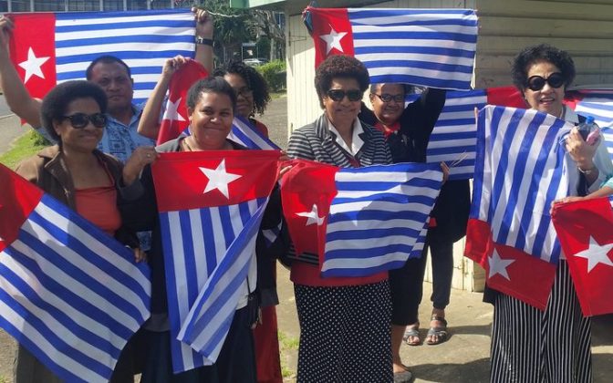 Ro Teimumu Kepa (centre) with staff flying the West Papua flag. Photo: supplied